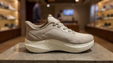Light beige athletic sneaker with thick sole and breathable mesh design