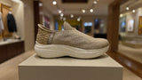 Minimalist beige sock-style sneaker featuring textured knit upper and white platform sole